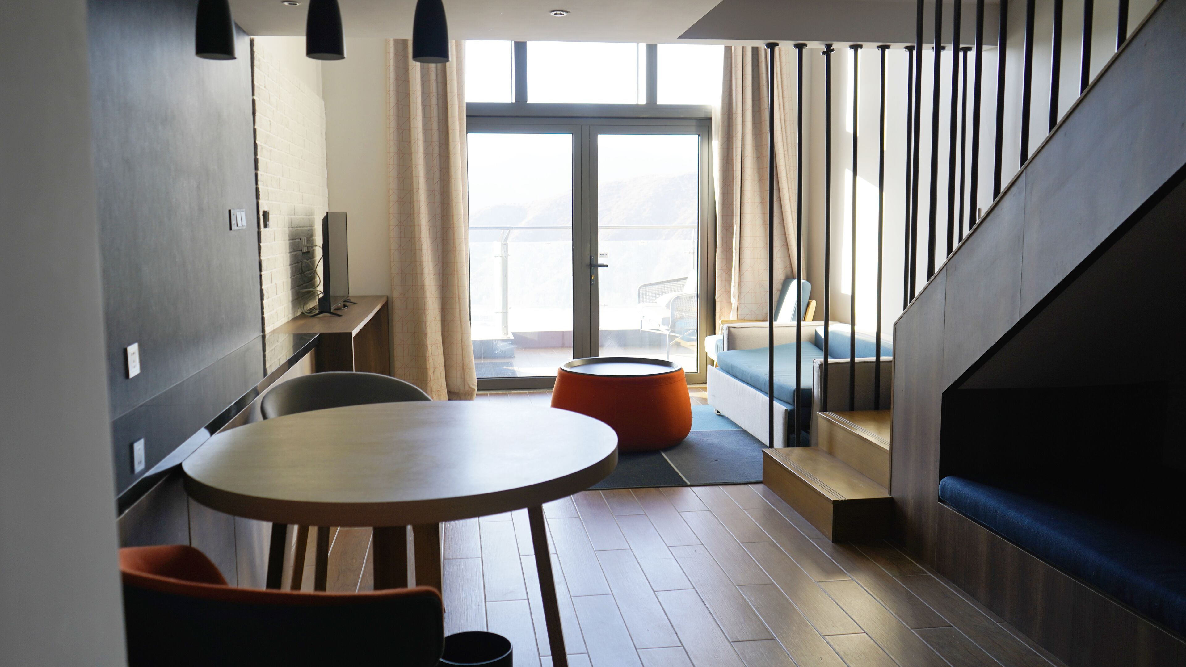 Een modern interieur met een eethoek, een bank en een trap.