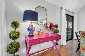 A pink desk with a blue lamp, a mirror, and decorative items including a bicycle and flowers. - Golf Course 26C - Directly on Golf Course, Including 50% off Golf Daily! (Miramar Beach)