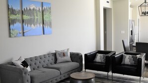 A modern living room with a grey sofa, black armchairs, and a striped rug. - Stylish modern home- explore PNW Hike work from home or explore nearby wineries  (Battle Ground)