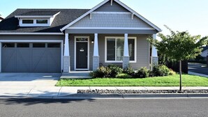 A single-story house with a garage, a front porch, and a small front yard. - Stylish modern home- explore PNW Hike work from home or explore nearby wineries  (Battle Ground)