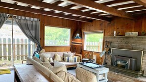 A cozy cabin interior with a wooden bench, sofa, and fireplace. - Bodega Bay - Sonoma Coastline (Bodega Bay)