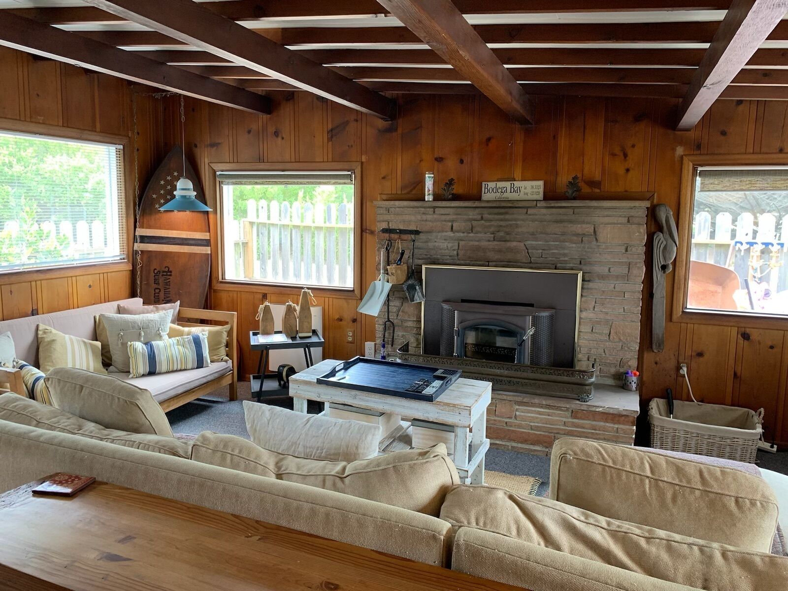 Un salon chaleureux avec une cheminée, des murs en bois et un canapé.
