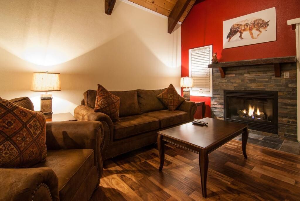 Un salón acogedor con chimenea, sofás de cuero y cojines estampados.