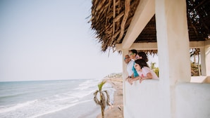A beachside structure with a thatched roof overlooking the ocean.
