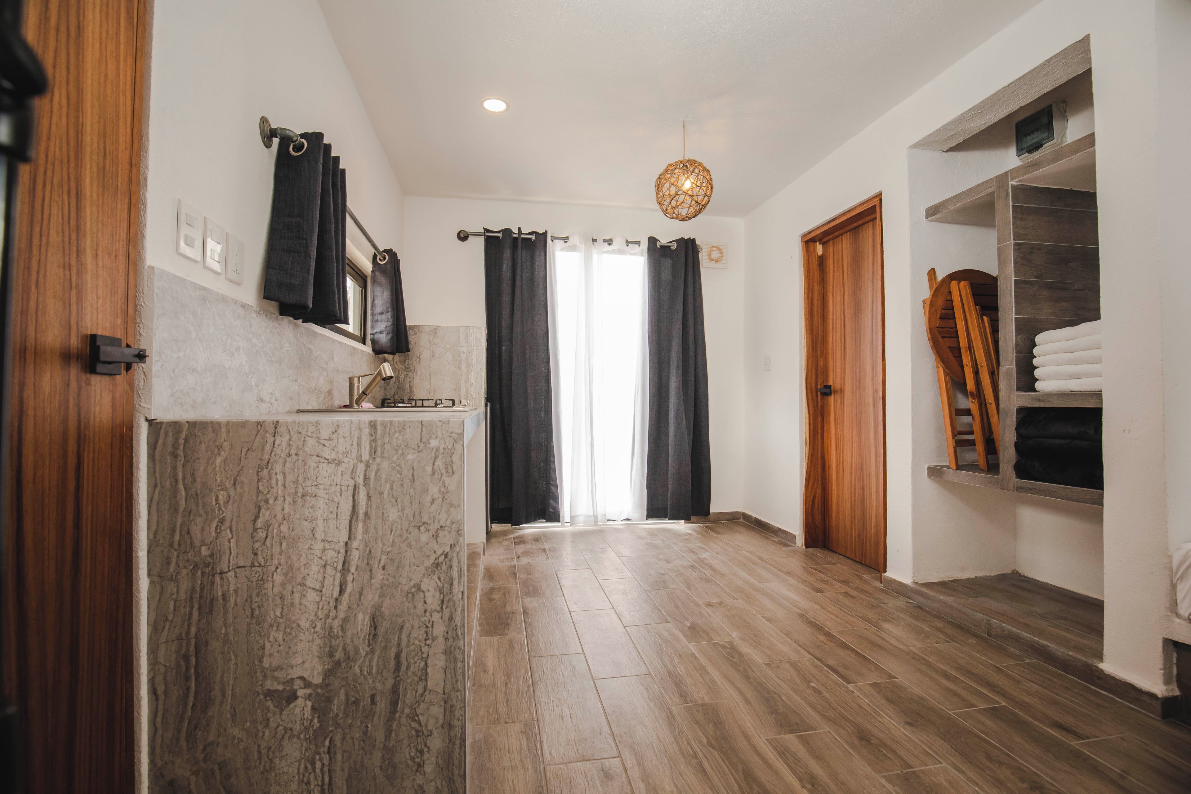 Une salle de bain avec un comptoir en marbre, une porte en bois et un porte-serviettes.