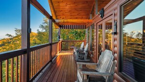 Una terrazza in legno con sedute all'aperto e ampie finestre.