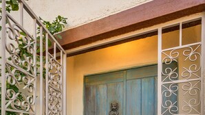 A wooden door with a decorative metal gate, a potted plant, and a patterned rug. - Midtown home with Pool Spa, fire pit, close to U of A, Restaurants, & Shopping (Tucson)