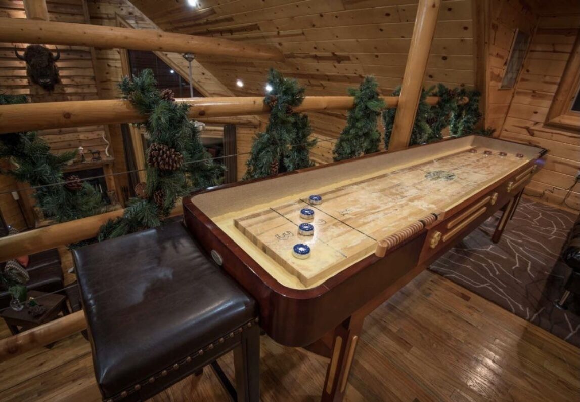Una mesa de fútbol de madera en una cabaña con un banco, rodeada de adornos navideños.