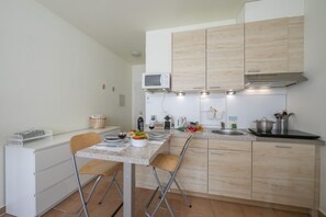 Una cocina moderna con armarios de madera, un microondas y una campana extractora de acero inoxidable.