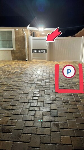 A paved entrance area with a sign marked "ENTRANCE" and a parking sign.