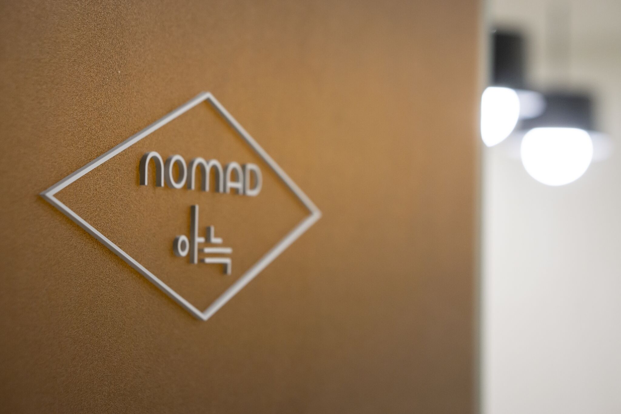 A sign with the word "nomad" and a symbol.