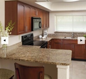 Enjoy cooking in this well-equipped kitchen with a window, sink, and ample countertop space.