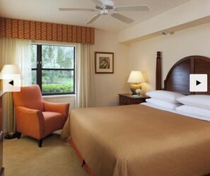 Relax in comfort with a large bed, armchair, and nightstand, surrounded by a clean and organized space.
