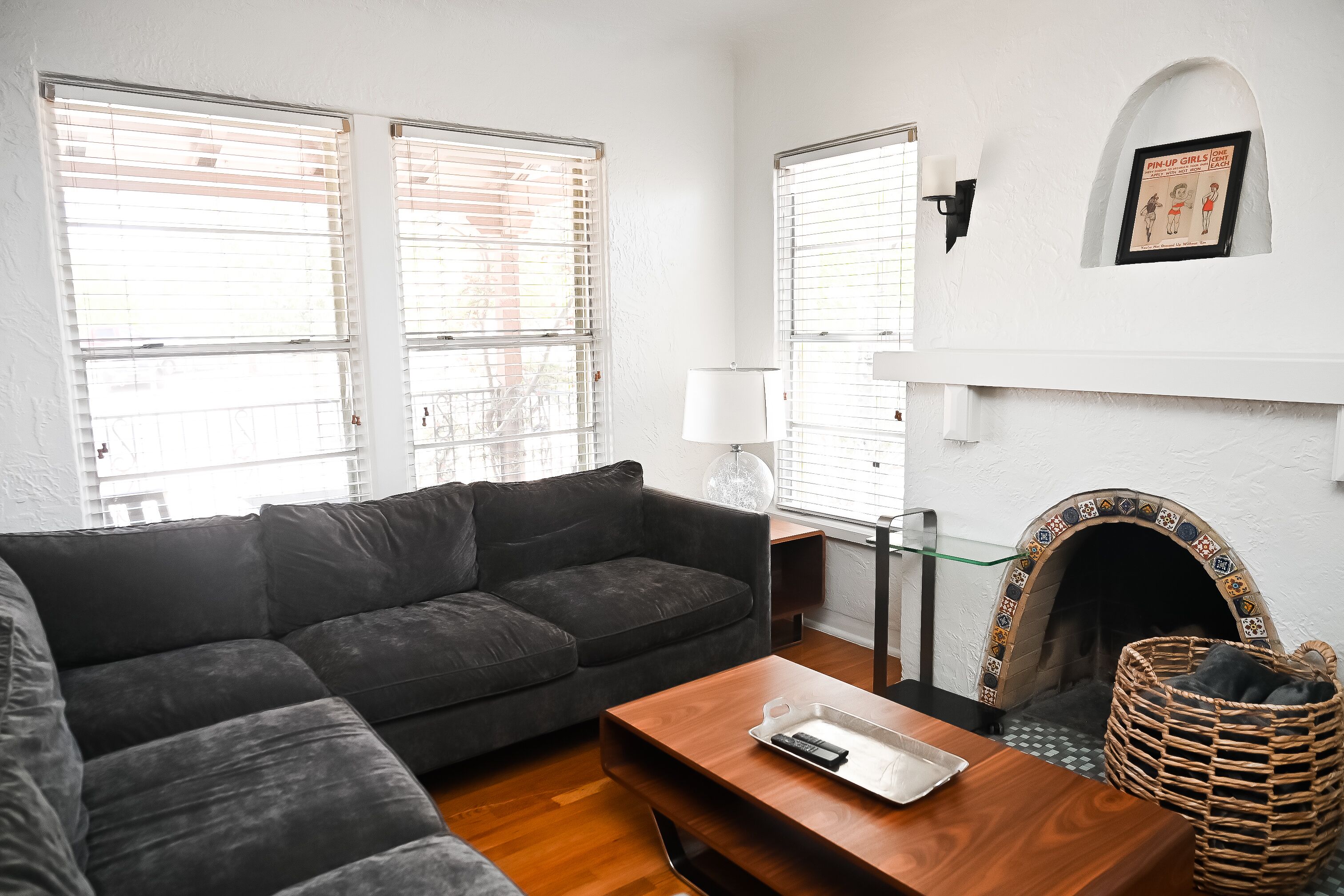 Ein Wohnzimmer mit Sofa, Couchtisch, Kamin und einem gerahmten Bild an der Wand.