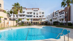 A swimming pool with metal railings, surrounded by a paved area, with multi-story buildings in the background. - Vacation Home Penthouse La Cala De Mijas with Sea View, Pool (La Cala de Mijas)