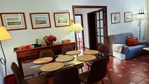 A dining area with a glass table, woven placemats, and framed pictures on the wall. - Holiday Home 'New House In Malaga Nature' with Mountain Views, Wi-Fi and Air Conditioning (Málaga)