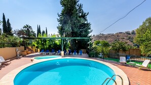 A swimming pool with lounge chairs and a pergola. - Holiday Home 'New House In Malaga Nature' with Mountain Views, Wi-Fi and Air Conditioning (Málaga)