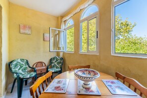 A dining area with a wooden table, chairs, and a bowl.