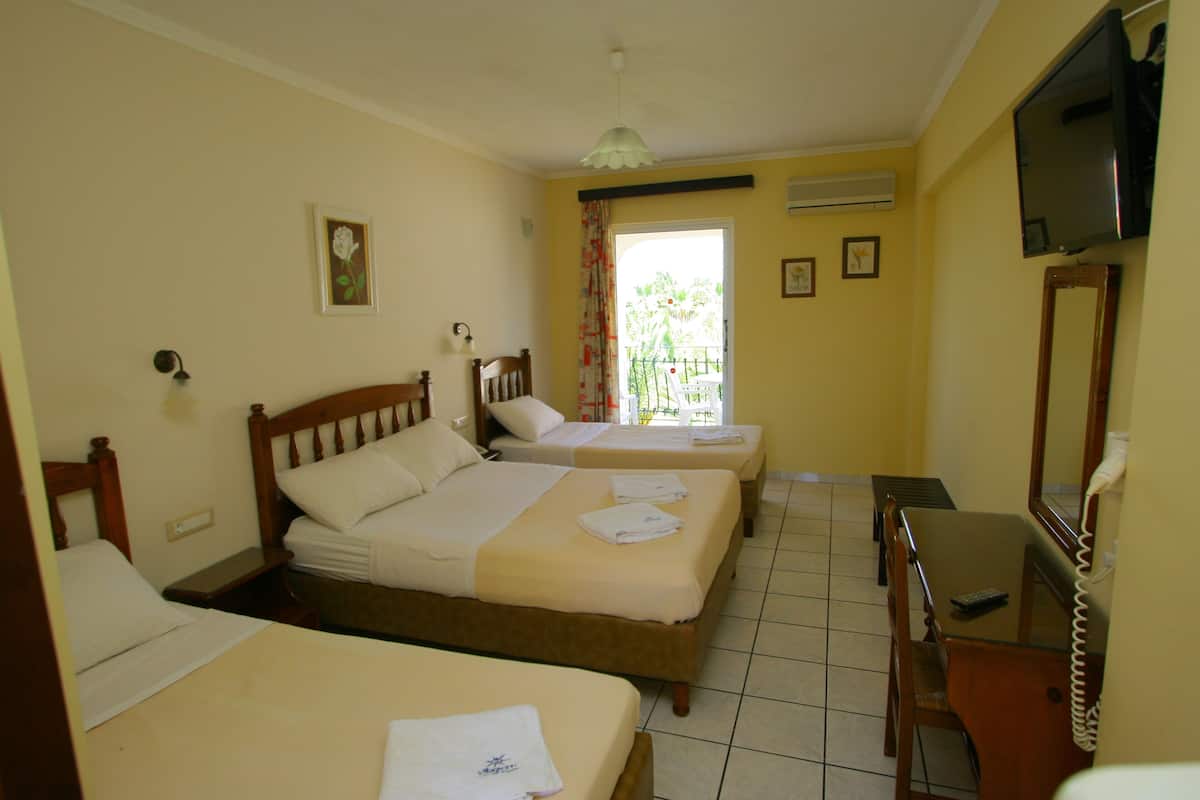 A hotel room with two beds, a desk, a chair, a television, and a balcony with a view.