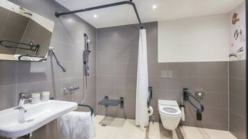 A modern bathroom with a shower, toilet, and sink.