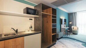Una cocina moderna con microondas integrado, un fregadero y un armario de madera.