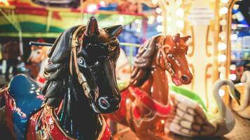 Carousel horses with a reflective surface and a swan.