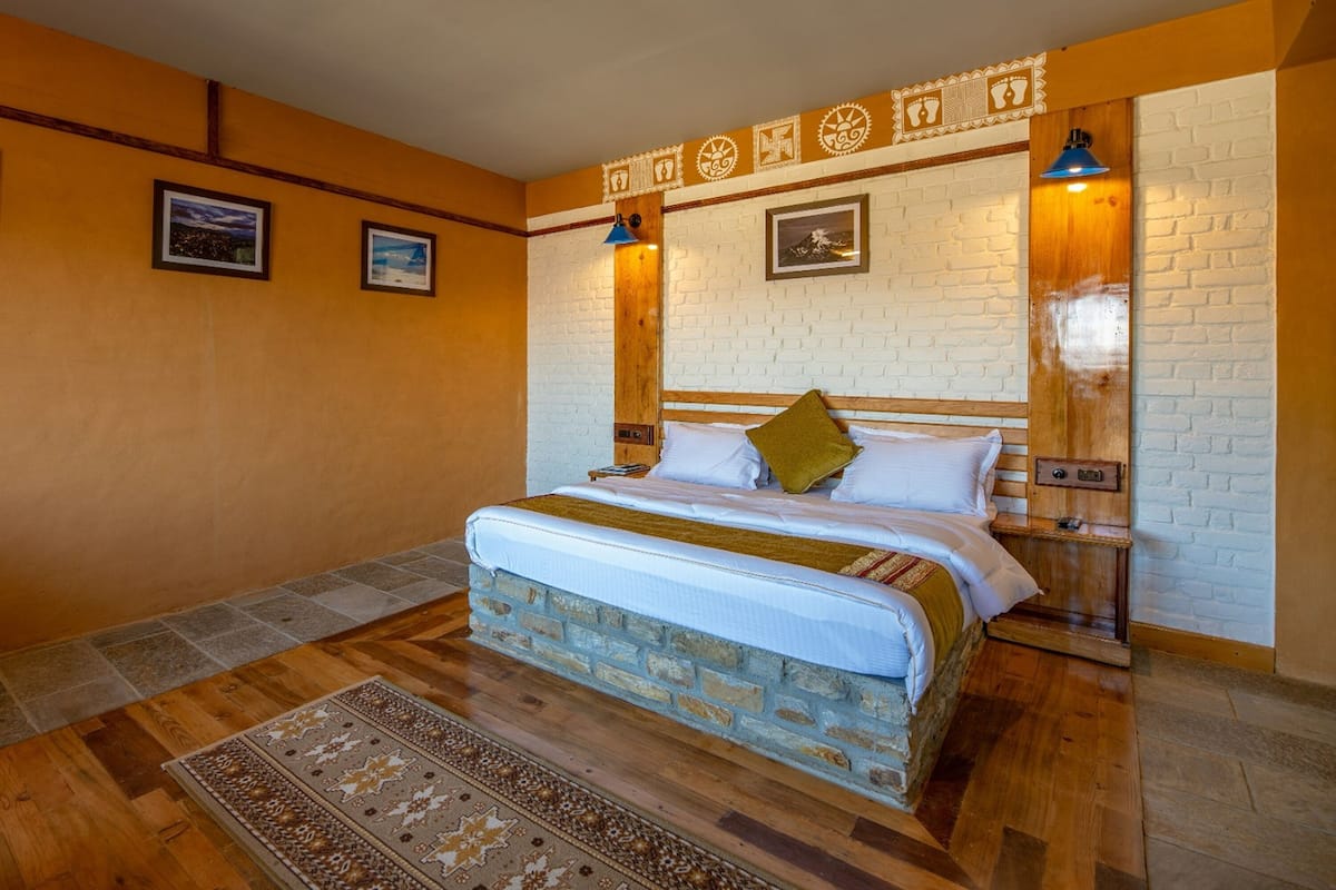 Een slaapkamer met een bed met een baksteenmotief, een houten hoofdbord en een decoratieve wand met ingelijste foto's.