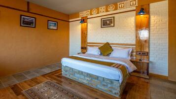 A bedroom with a brick-patterned bed, wooden headboard, and a decorative wall with framed pictures.