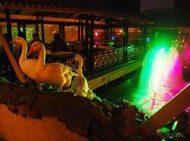 Un restaurante con una fuente de agua y esculturas de cisnes.