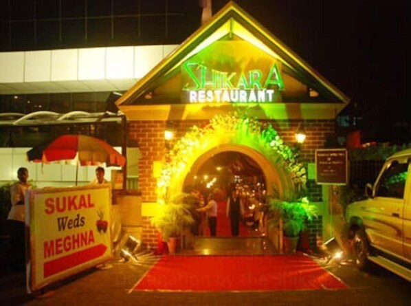 A restaurant named 'Slikara' with a red carpet entrance and a signboard for 'Sukal Weds Meghna'. - Hotel Highway View (Shikara) (Navi Mumbai)