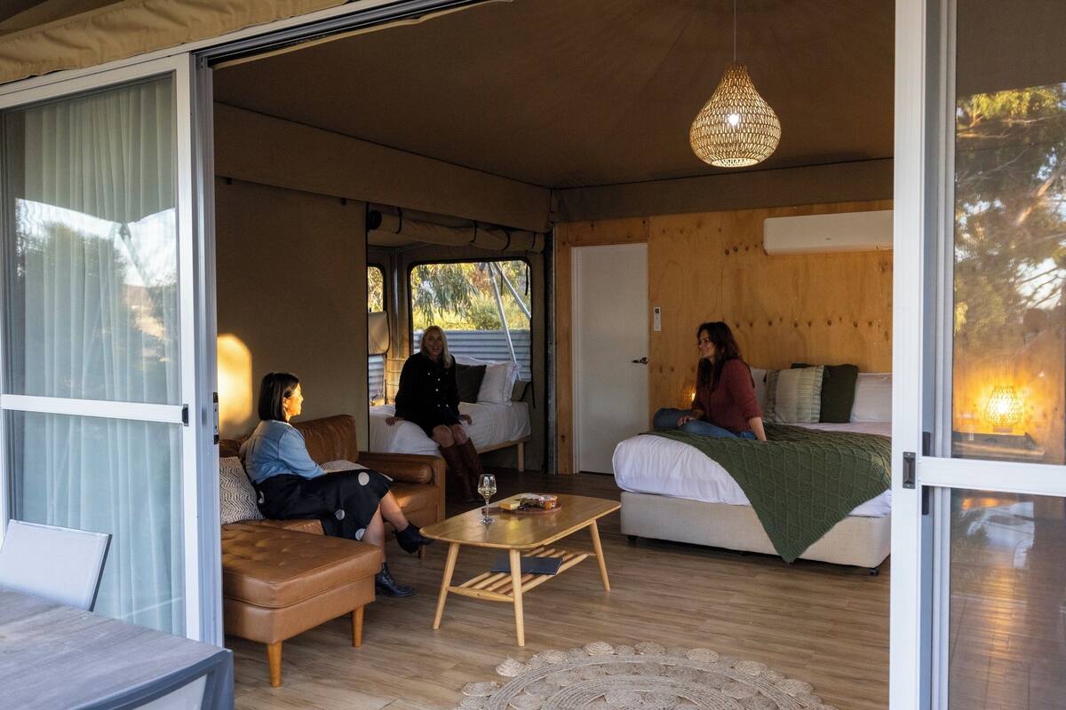 Un ambiente acogedor con un sofá, una mesa de centro y una cama.