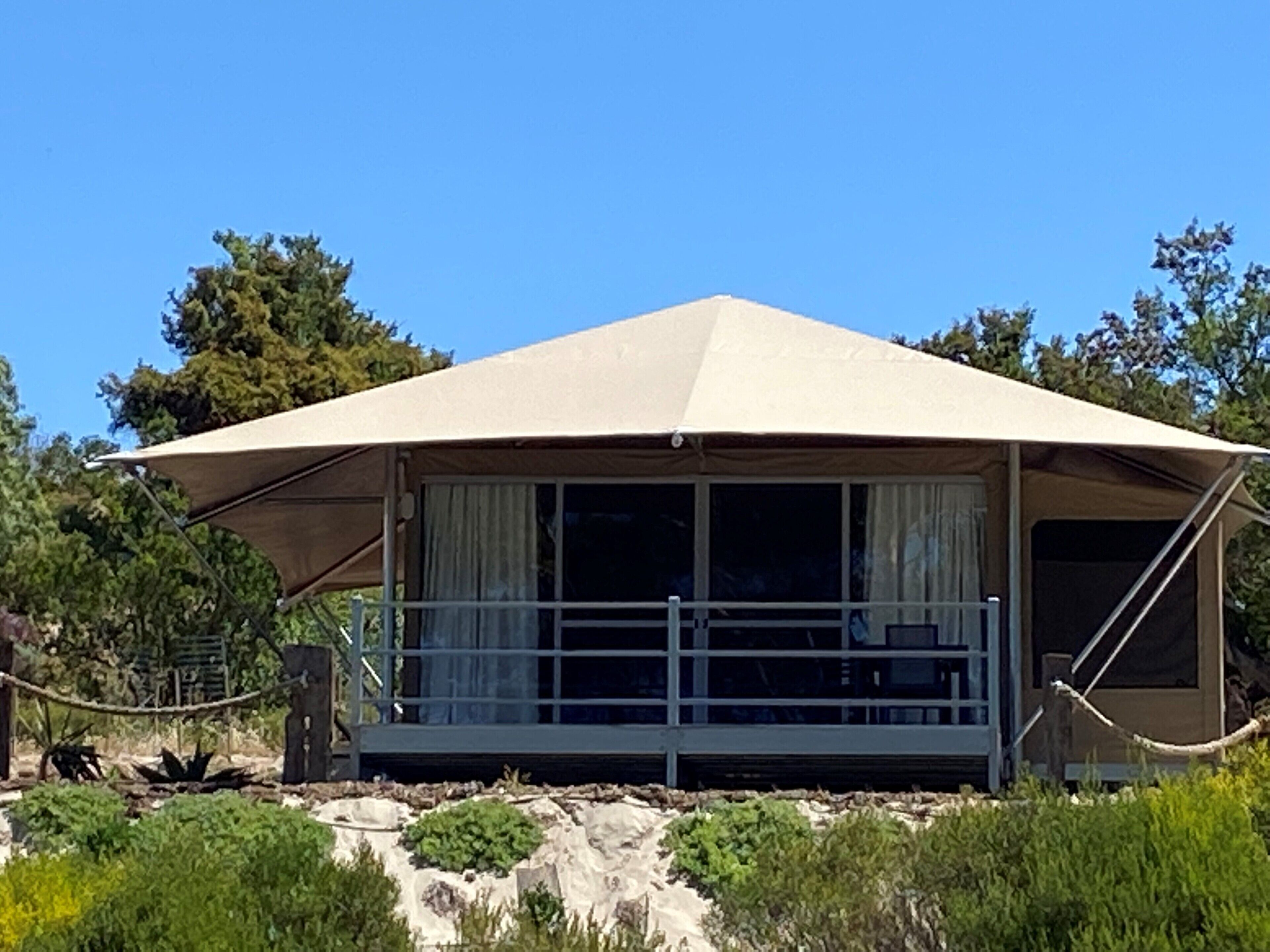 A single-story, A-frame structure with a covered porch and large windows.