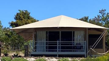 A single-story, A-frame structure with a covered porch and large windows.