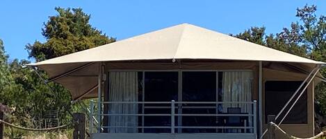Una estructura en forma de A de un solo nivel con un porche cubierto y ventanas grandes.