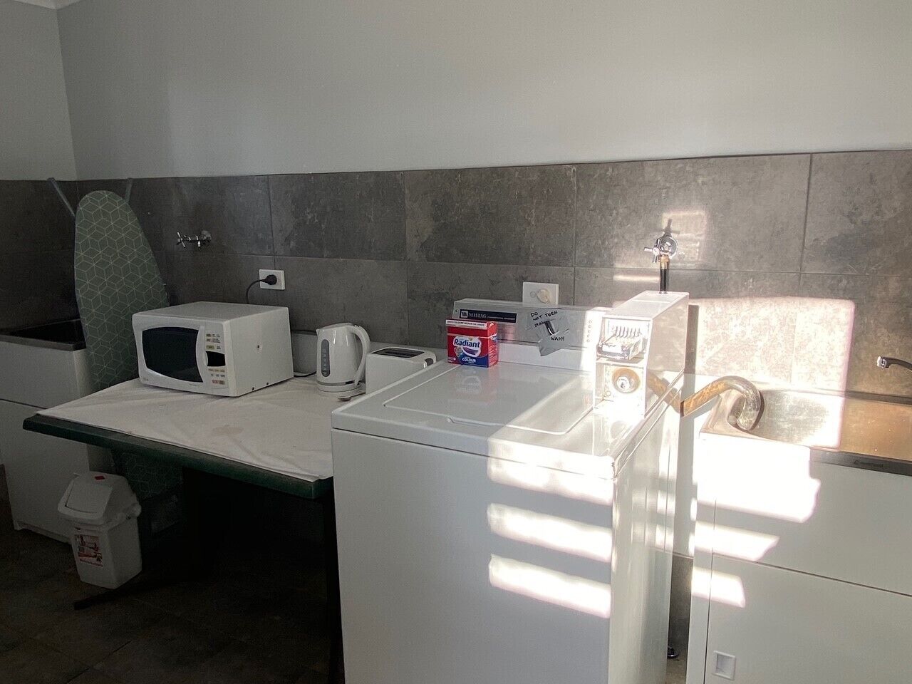 A compact kitchen with a microwave, toaster, and kettle on a countertop.
