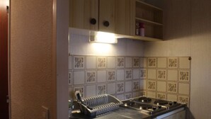 A kitchen with wooden cabinets, a gas stove, and a patterned backsplash.