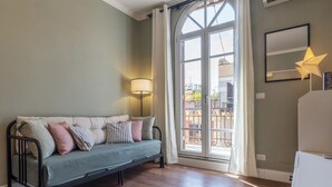 A room with a sofa, a lamp, a window with curtains, and a star-shaped light fixture. - GuestHost - Comfortable and quiet 90sqm apartment that can accommodate up to 6 people. Located on the sixth floor, without lift (not suitable for the disabled, steps to access), of a renovated period building in Trastevere area, the apartment is located  (Roma)