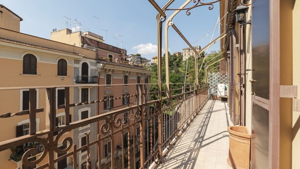 A balcony with wrought iron railings overlooking a city street. - GuestHost - Comfortable and quiet 90sqm apartment that can accommodate up to 6 people. Located on the sixth floor, without lift (not suitable for the disabled, steps to access), of a renovated period building in Trastevere area, the apartment is located  (Roma)