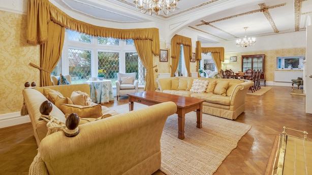 Ein geräumiges Wohnzimmer mit einem großen Holztisch, zwei Sofas und einem Kronleuchter.