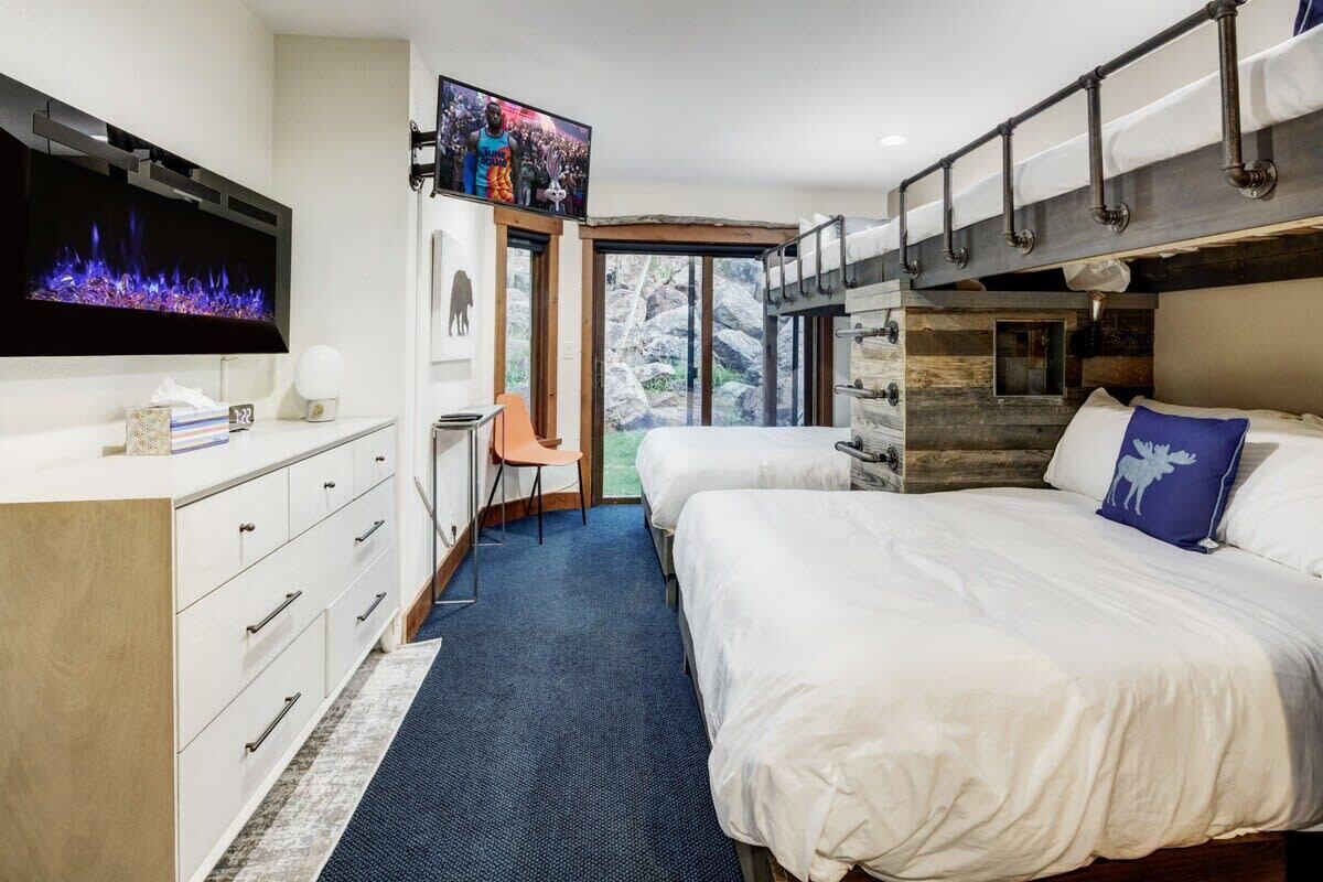 Een moderne hotelkamer met een groot bed, een bureau, een televisie en uitzicht op het omliggende landschap.