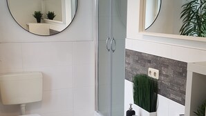 A modern bathroom with a toilet, sink, and shower.