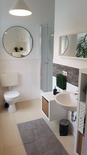 Un baño moderno con inodoro, lavabo y ducha.
