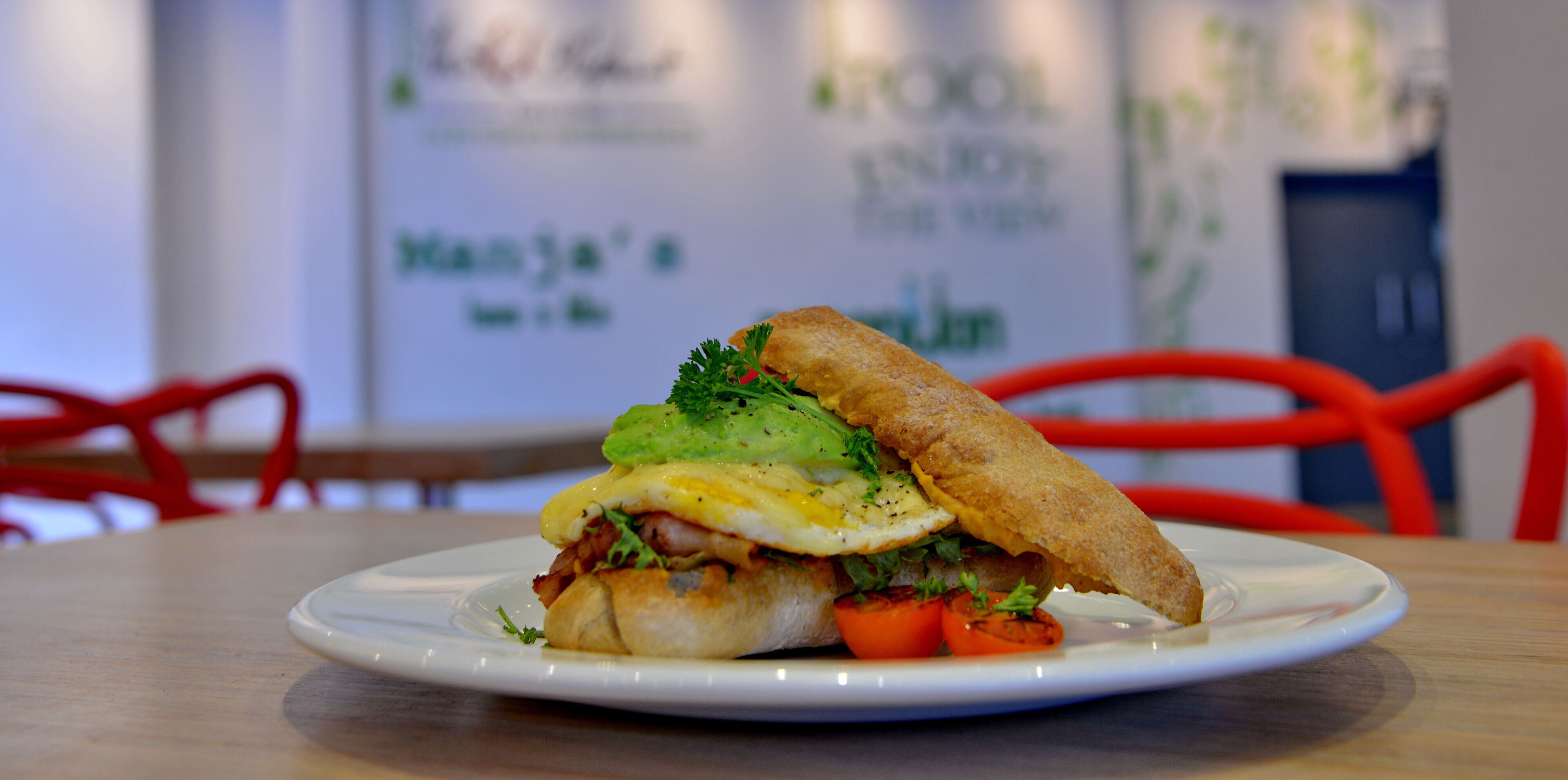 A sandwich on a white plate on a wooden table.