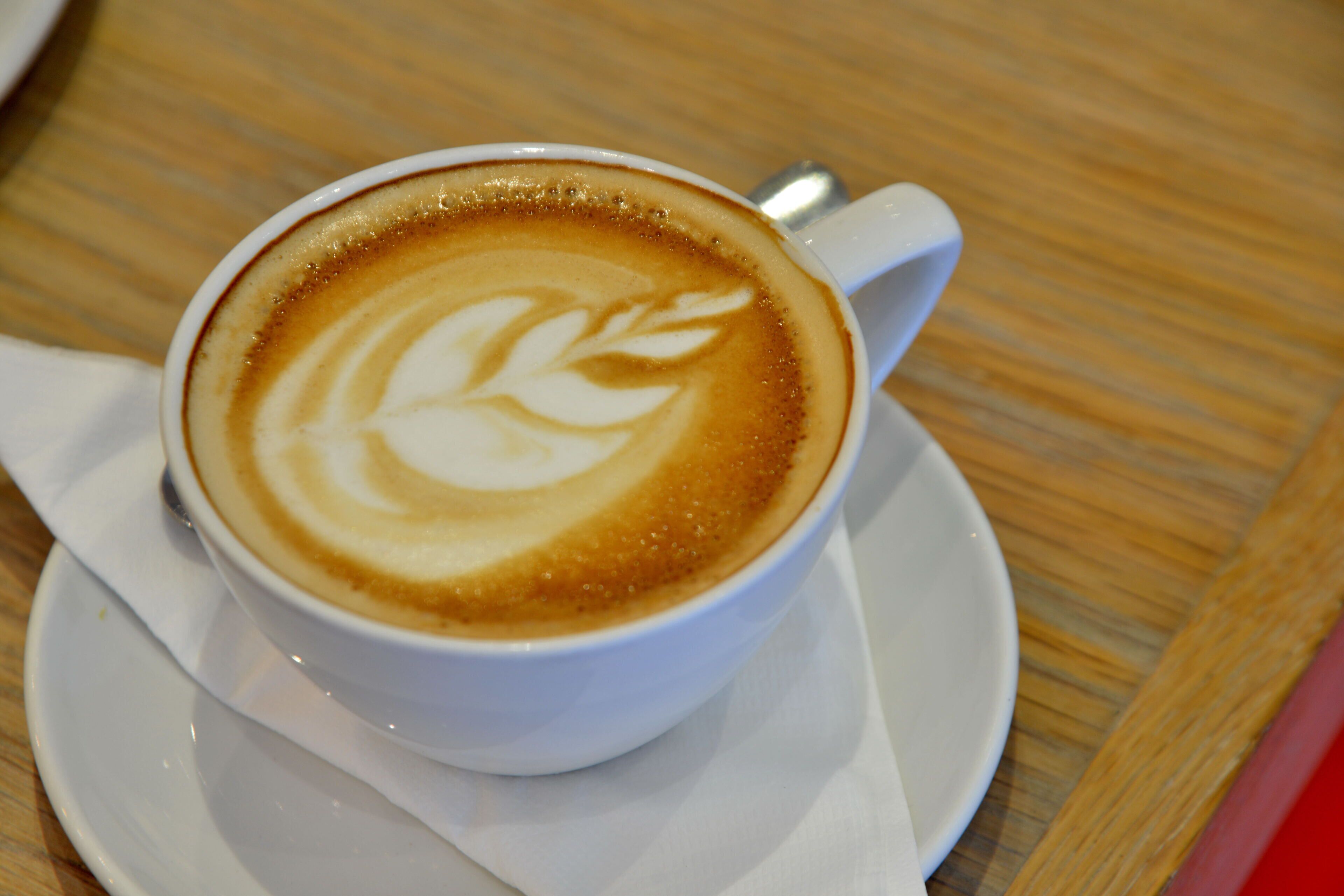 A cup of coffee with latte art on a saucer.