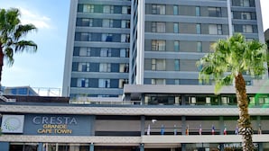 Un hôtel moderne, situé dans un immeuble de grande hauteur, doté de nombreux étages, de grandes fenêtres et d’une entrée bien visible.
