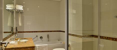 A modern bathroom with a glass shower enclosure, a double sink vanity, and a toilet.