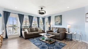 A modern living room with two sofas, a coffee table, and a patterned rug.