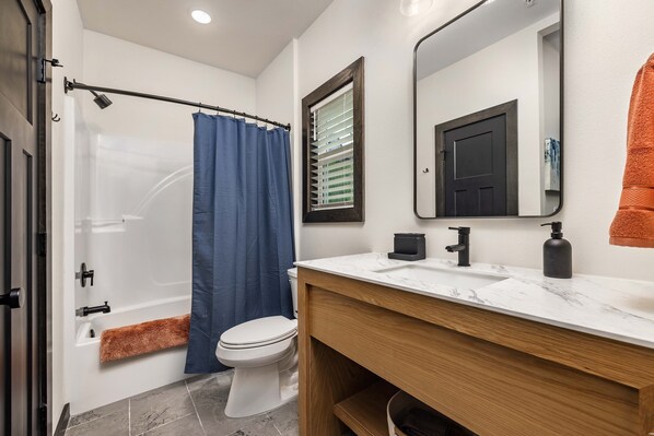 Un baño moderno con ducha, inodoro y tocador.