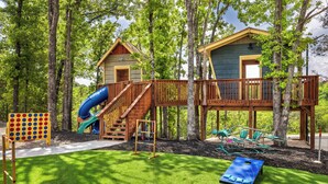 A playground with a slide, swings, and a climbing structure. - Luxury Lakefront Lodge | 6BR Modern Retreat + FREE Tickets, Pools & Amenities (Kimberling City)