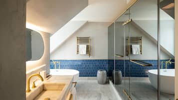 A modern bathroom with two sinks, a large mirror, and a glass shower enclosure.